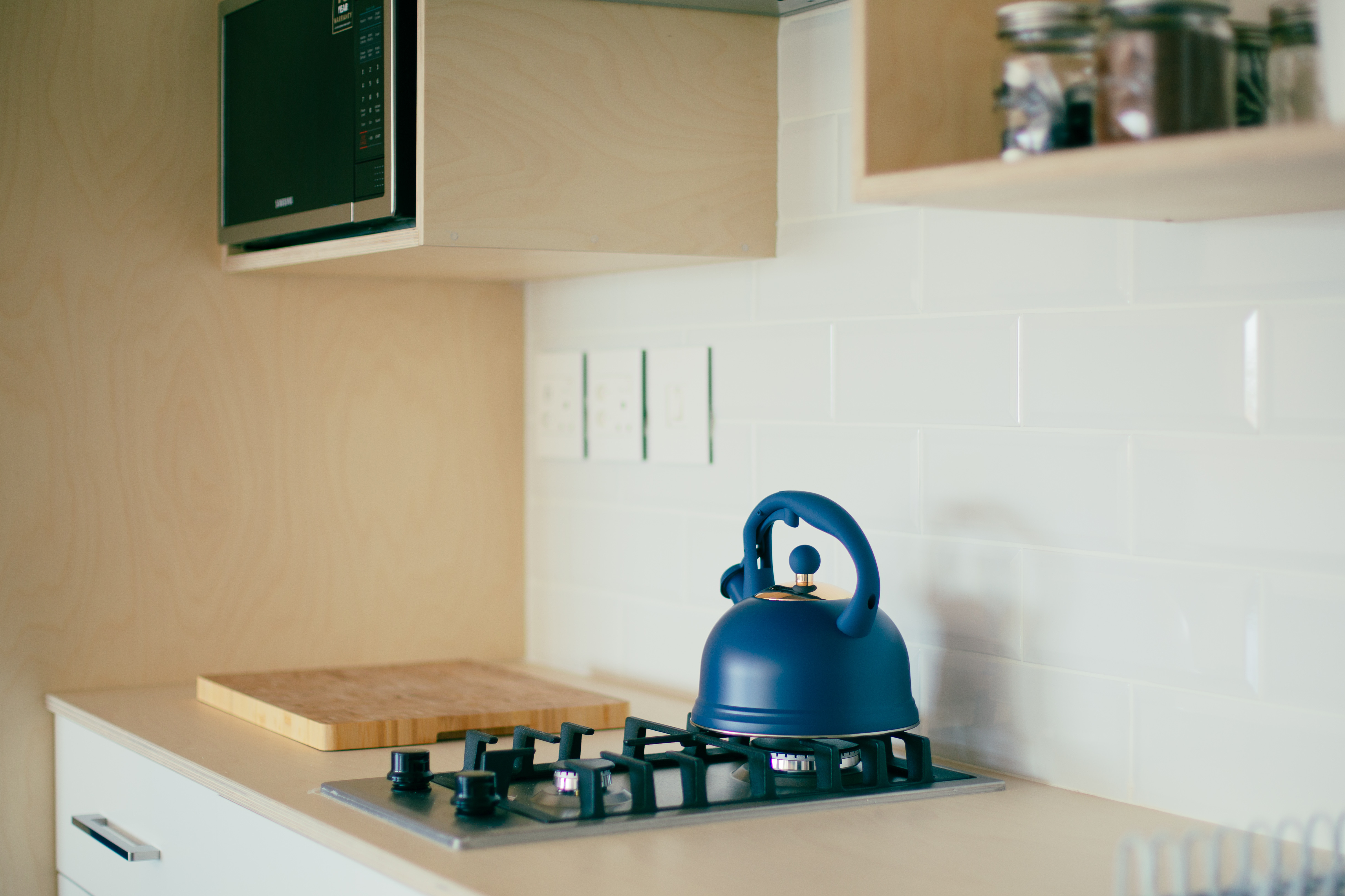 Wider view of the kitchen counter with cookware and a coffee station.
